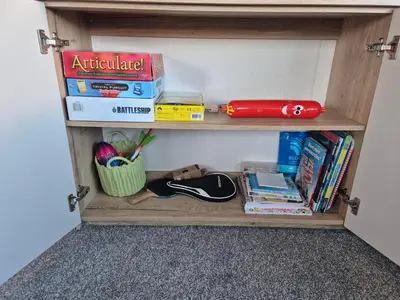 a book shelf with books and other items on it at 3 Bedroom 2 Bathroom Caravan Charlie Delta in Saint Osyth