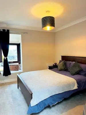 a bedroom with a large bed and a window at Modern House Soham Town Centre in Soham