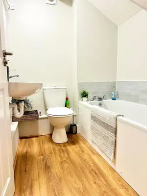 a bathroom with a toilet and a sink and a tub at Modern House Soham Town Centre in Soham
