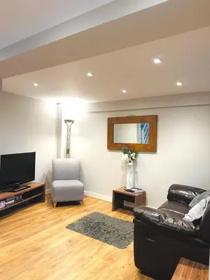 a living room with a couch and a tv and a chair at Modern House Soham Town Centre in Soham