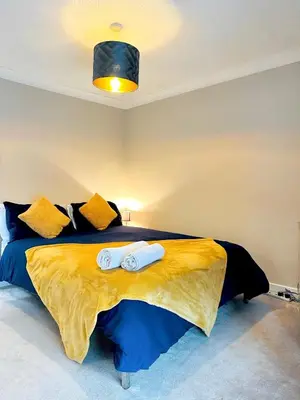 a bedroom with a bed with two towels on it at Modern House Soham Town Centre in Soham