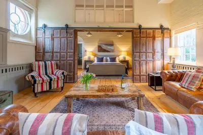 a living room with a bed and a table at Belchamp Hall Stables in Belchamp Otten