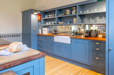 a kitchen with blue cabinets and a sink at Belchamp Hall Stables in Belchamp Otten