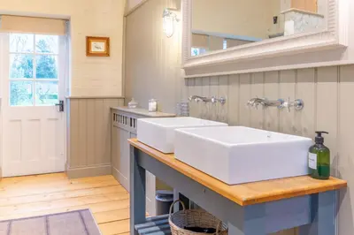 a bathroom with two white sinks on a counter at Belchamp Hall Stables in Belchamp Otten