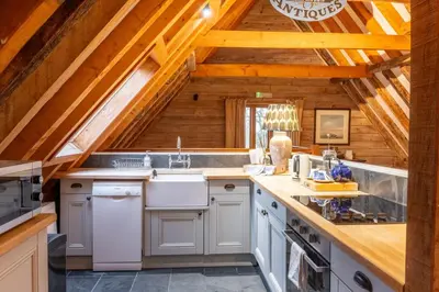 a kitchen with white appliances and a wooden ceiling at Belchamp Hall Hayloft in Belchamp Otten