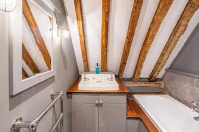 a bathroom with a sink and a bath tub at Belchamp Hall Hayloft in Belchamp Otten