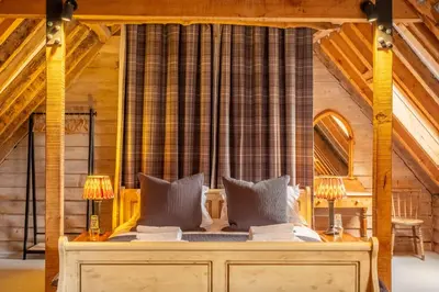 a bedroom with a bed with two lamps on it at Belchamp Hall Hayloft in Belchamp Otten