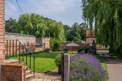 a garden with a fence and purple flowers at Belchamp Hall Hayloft in Belchamp Otten