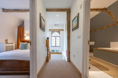 a bedroom with a bed and a sink in a room at Belchamp Hall Coach House in Belchamp Otten