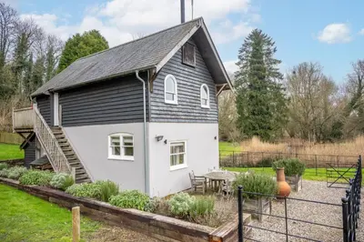 a small black and white house with a table at Belchamp Hall Mill in Belchamp Otten