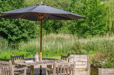 an umbrella sitting on a table in a garden at Belchamp Hall Mill in Belchamp Otten