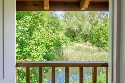 a window with a view of a river from a porch at Belchamp Hall Mill in Belchamp Otten