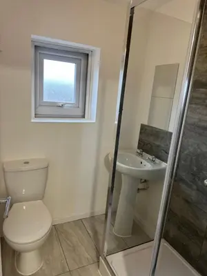a bathroom with a toilet and a sink and a window at Basildon Everlight Villa in Basildon