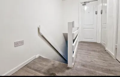 a hallway with a white staircase with a door at Basildon Everlight Villa in Basildon