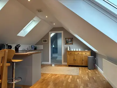 an attic kitchen with a skylight and a counter at Magog View in Sawston
