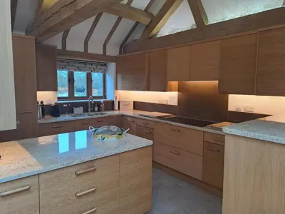 a large kitchen with wooden cabinets and a counter top at Low Farm Barn, a family and dog friendly haven in Brundish