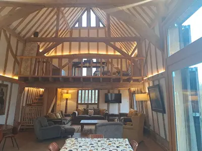 a living room with a large wooden ceiling at Low Farm Barn, a family and dog friendly haven in Brundish