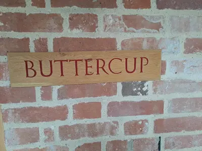 a sign on a brick wall with the word butrevenant at Low Farm Barn, a family and dog friendly haven in Brundish