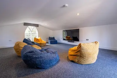 a living room with three blue couches and a tv at The Cat House in Woolverstone
