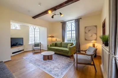 a living room with a green couch and a table at The Cat House in Woolverstone