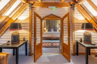 a room with two tables and a room with a bed at Belchamp Hall Hayloft and Stables in Belchamp Otten