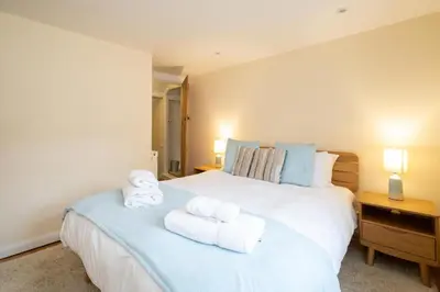 a bedroom with a large white bed with towels on it at Emeny Cottage - Aldeburgh Coastal Cottages in Aldeburgh