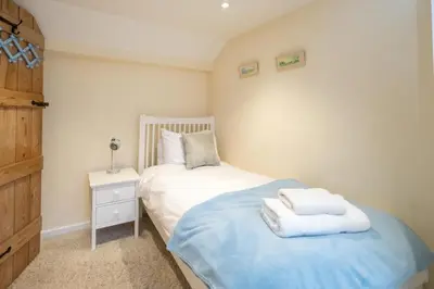 a bedroom with a bed with towels on it at Emeny Cottage - Aldeburgh Coastal Cottages in Aldeburgh