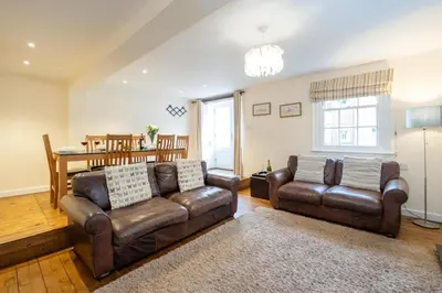 a living room with two leather couches and a table at Emeny Cottage - Aldeburgh Coastal Cottages in Aldeburgh