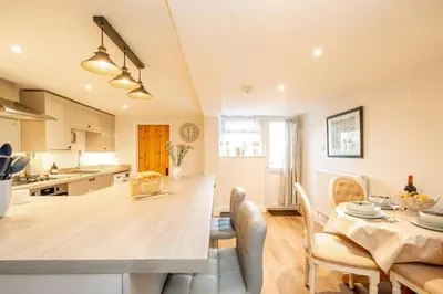 a kitchen and dining room with a table and chairs at 7 Prospect Place - Aldeburgh Coastal Cottages in Leiston