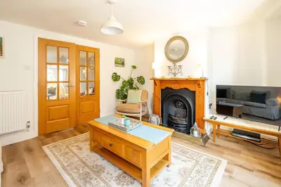 a living room with a table and a fireplace at 7 Prospect Place - Aldeburgh Coastal Cottages in Leiston