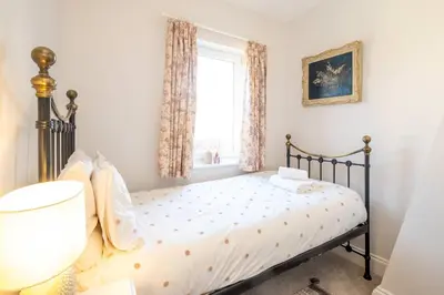 a bedroom with a bed and a window at 7 Prospect Place - Aldeburgh Coastal Cottages in Leiston