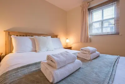 a bedroom with a bed with towels on it at 9 Reade Court, Aldeburgh in Aldeburgh