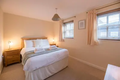 a bedroom with a large bed with two towels on it at 9 Reade Court, Aldeburgh in Aldeburgh