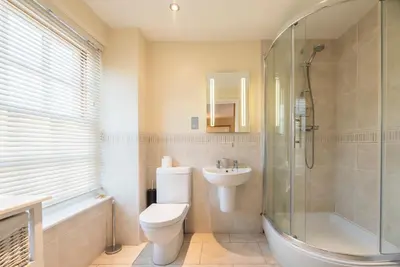 a bathroom with a toilet and a shower and a sink at 9 Reade Court, Aldeburgh in Aldeburgh