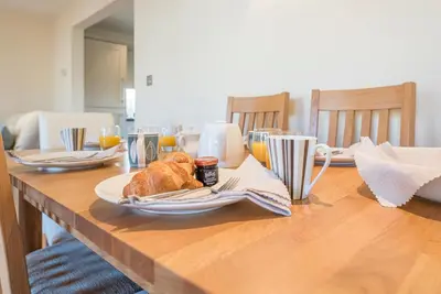 a wooden table with a plate of food on it at 9 Reade Court, Aldeburgh in Aldeburgh