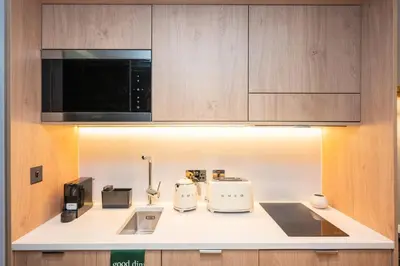 a kitchen counter with two toasters and a microwave at Wilde Cambridge City Centre in Cambridge