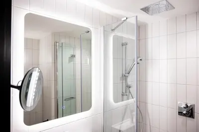 a bathroom with a shower and a mirror at Wilde Cambridge City Centre in Cambridge