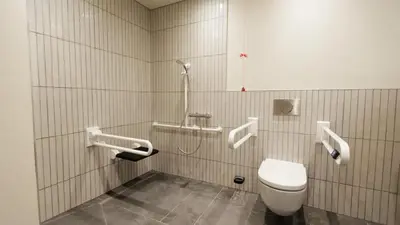 a bathroom with a toilet and a shower in it at Wilde Cambridge City Centre in Cambridge