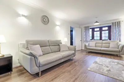 a living room with a couch and a tv at Stylish 5-Bed London Residence Featuring Garden, Parking & High-Speed Internet in Nevendon