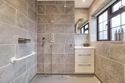 a bathroom with a shower and a sink at Stylish 5-Bed London Residence Featuring Garden, Parking & High-Speed Internet in Nevendon