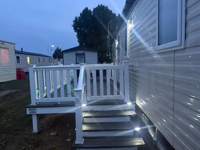 a white staircase with lights on the side of a house at 6 Beds 2 Sofa bed Family friendly - unlimited Wi-Fi, Warm, Cozy Sun decking Caravan at Seawick Holiday Park in Saint Osyth