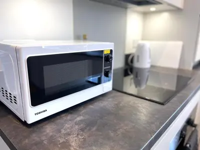 a microwave sitting on a counter in a kitchen at New Modern 2 Bed with parking in BISHOPS STORTFORD, close to Stansted Airport! in Bishops Stortford