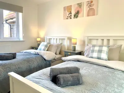 a room with three beds with pillows on them at New Modern 2 Bed with parking in BISHOPS STORTFORD, close to Stansted Airport! in Bishops Stortford