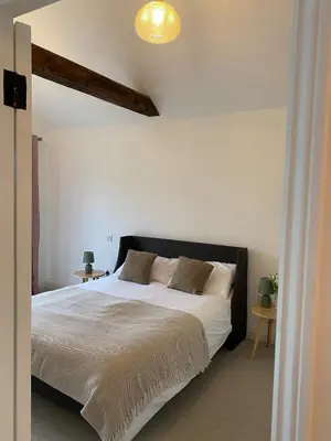 a bedroom with a large bed with white sheets and pillows at Number Forty One in Sudbury