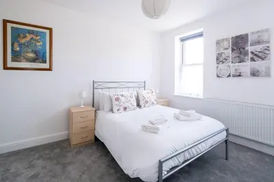 a white bedroom with a bed and a window at 2 Volunteer House, Leiston - Aldeburgh Coastal Cottages in Leiston