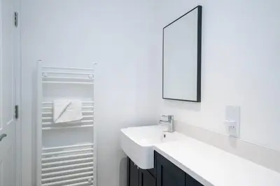 a white bathroom with a sink and a mirror at 2 Volunteer House, Leiston - Aldeburgh Coastal Cottages in Leiston