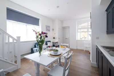a kitchen and dining room with a white table and chairs at 2 Volunteer House, Leiston - Aldeburgh Coastal Cottages in Leiston