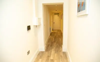 a hallway with white walls and a wooden floor at Seaview Apartments - 30 Marine Parade, Harwich - Perfect for business & long term stays in Harwich