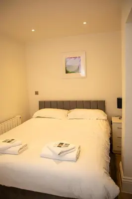 a bedroom with a bed with two towels on it at Seaview Apartments - 30 Marine Parade, Harwich - Perfect for business & long term stays in Harwich