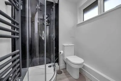 a bathroom with a toilet and a glass shower at Cosy 1-Bed Apt in Newmarket with Parking in Newmarket